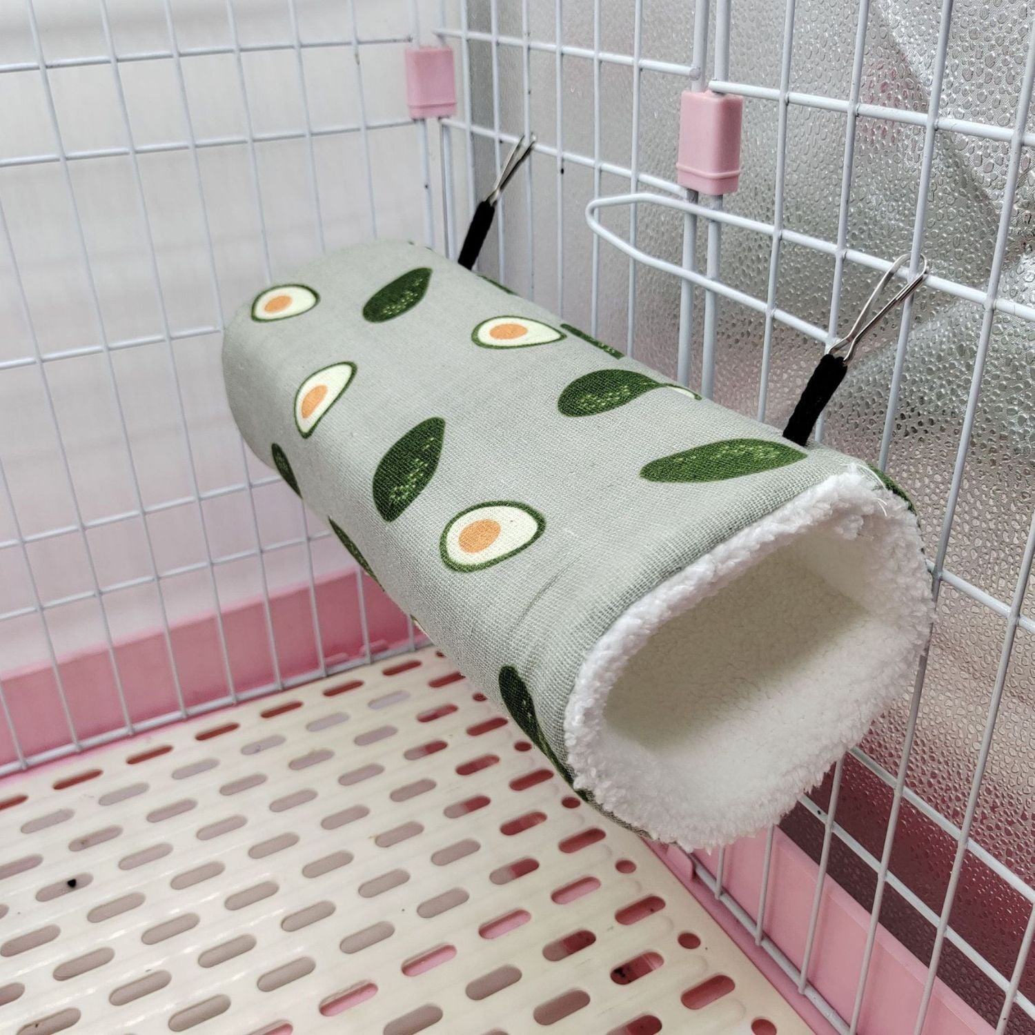 Cozy Critter Tunnel in grijze stof met avocado patroon opgehangen in kooi